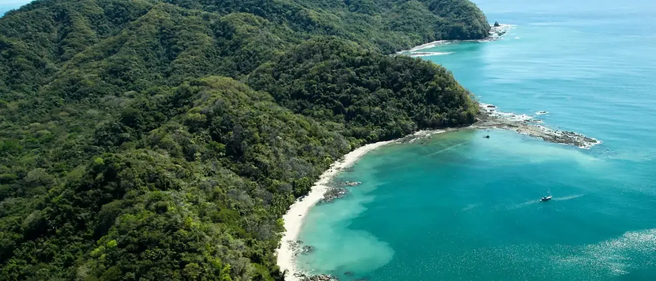 Exuberante floresta montanhas cobertas de esticar-se para o Golfo de Nicoya ao lado da praia rochosa e arenosa de Ballena Bay em Costa Rica