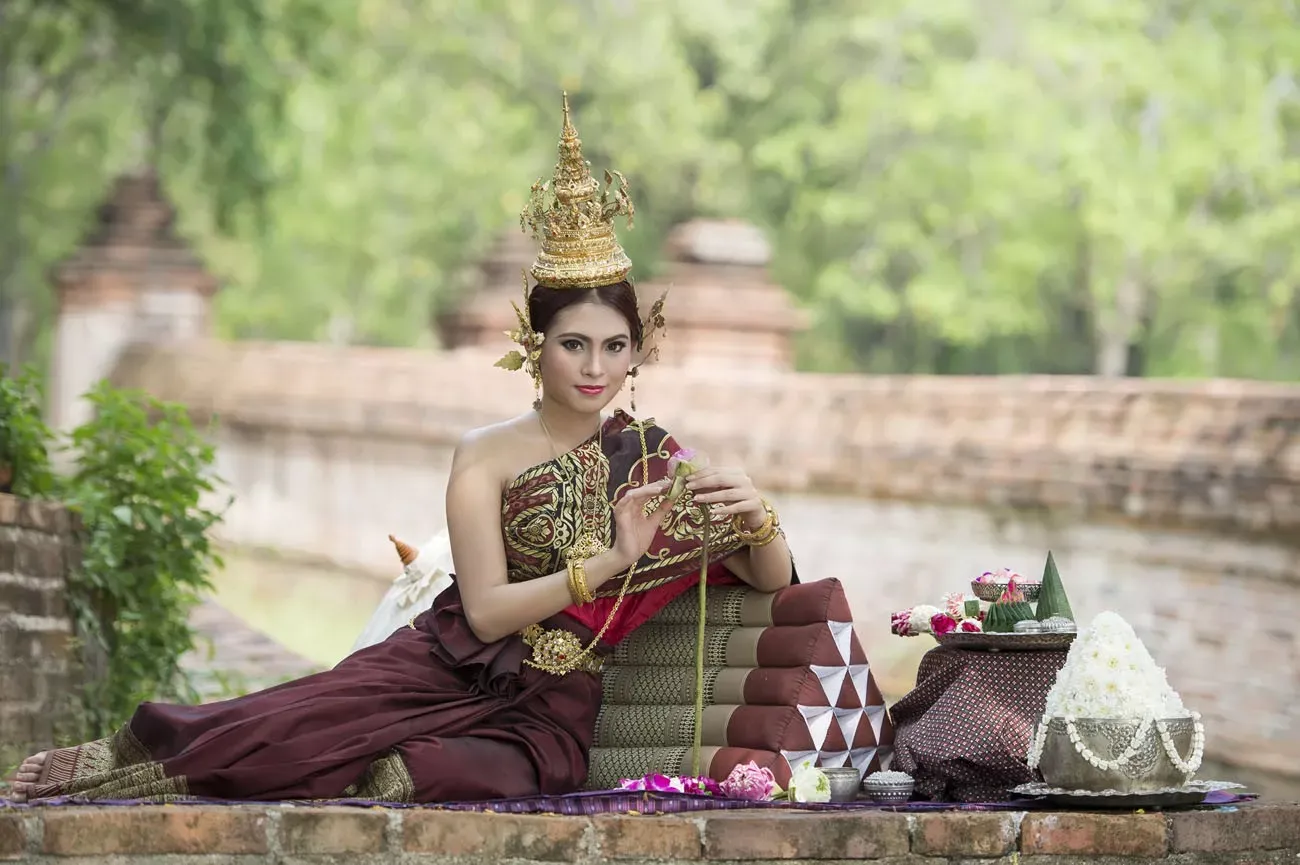 Mulher que desgasta o vestido thai típico com thai fundo do estilo do templo, cultura identidade de Tailândia