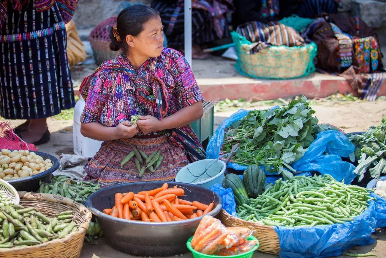 Uma mulher vende vegetais no mercado semanal tradicional em Solola