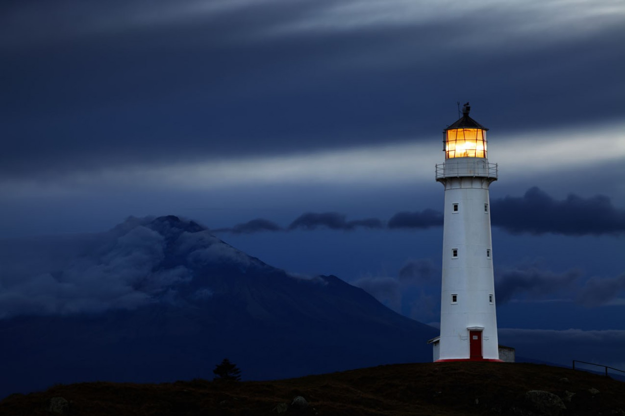 Cape Egmont Farol e Taranaki Mount no fundo, Nova Zelândia