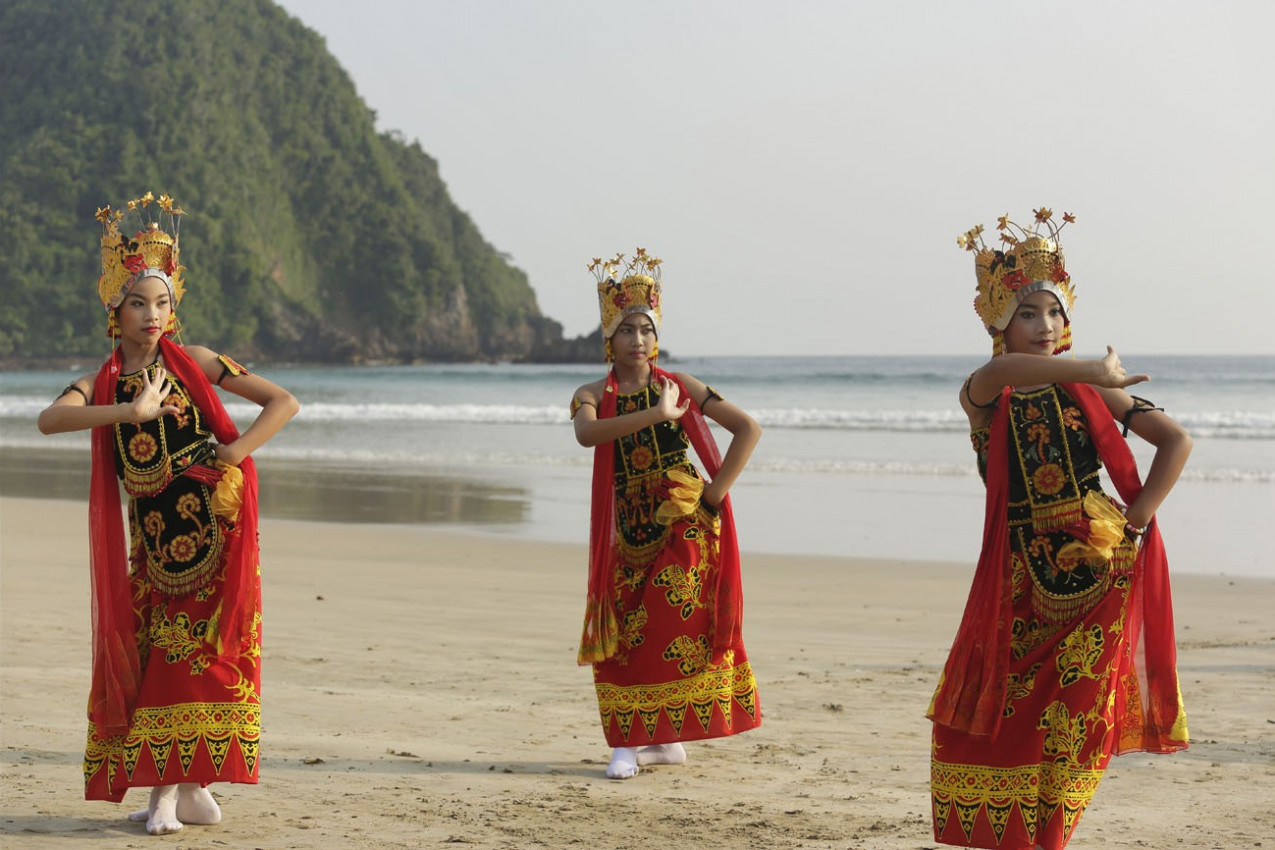 dançarinos populares indonésias realizar sua tradicional dança popular no litoral de Merah Beach, Banyuwangi