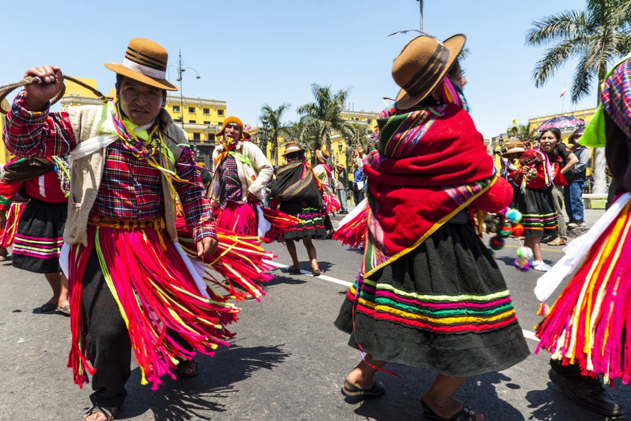 Índios em vestidos tradicionais do Peru dançando na praça Plaza de Armas